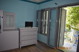 a room with a dresser with a television and a window at The central house! in Raches