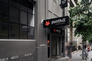 una persona che cammina su un marciapiede di fronte a un edificio di Punthill Apartment Hotel - Manhattan a Melbourne