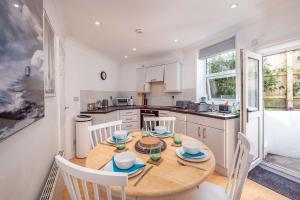 a kitchen with a wooden table with chairs and a dining room at Blue Winds and Waves in Cowes