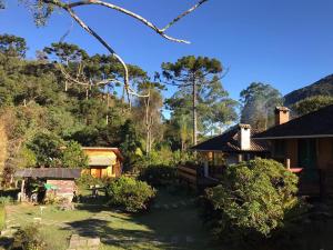 uma casa no meio de um quintal com árvores em Estalagem Engenho de Serra em Itamonte