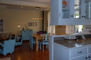 a kitchen with a table and a dining room at Casa da Quinta in Vila Franca do Campo