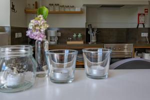 four glass cups sitting on a counter in a kitchen at Casa da Quinta in Vila Franca do Campo