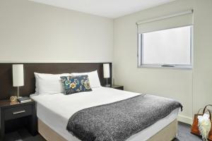 a bedroom with a large bed and a window at Punthill Essendon in Melbourne