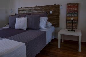 a bedroom with a bed with a headboard and a table at Casa da Quinta in Vila Franca do Campo