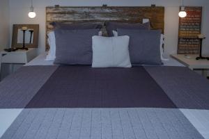 a large bed with blue and white pillows at Casa da Quinta in Vila Franca do Campo