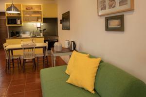a living room with a green couch and a kitchen at Casa da Quinta in Vila Franca do Campo