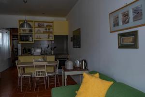 a living room with a green couch and a kitchen at Casa da Quinta in Vila Franca do Campo
