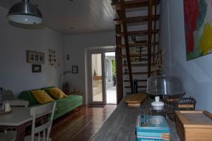 a living room with a green couch and a staircase at Casa da Quinta in Vila Franca do Campo
