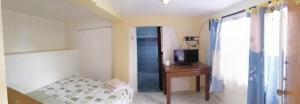 a bedroom with a bed and a desk and a television at VRC Resort in Almeria