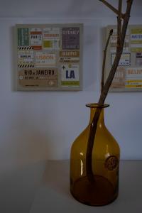 a yellow vase with branches in it on a table at Casa da Quinta in Vila Franca do Campo