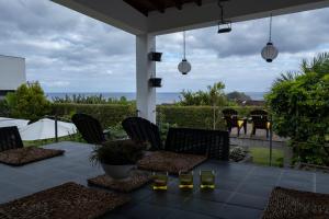 a patio with chairs and a table with wine glasses at Casa da Quinta in Vila Franca do Campo