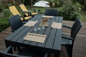 a black picnic table with chairs and an umbrella at Casa da Quinta in Vila Franca do Campo