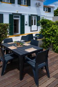 a black table and chairs on a wooden deck at Casa da Quinta in Vila Franca do Campo