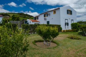 a white house with a garden in front of it at Casa da Quinta in Vila Franca do Campo