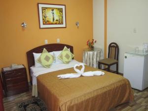 a hotel room with a bed with a towel on it at Hotel Plaza Trujillo in Trujillo