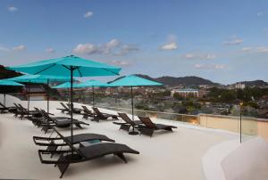 a group of chairs and blue umbrellas on a roof at Lahan Hotel Jeonju in Jeonju