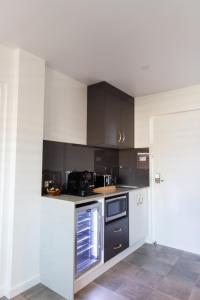 a kitchen with black and white cabinets and appliances at Fountain View Motel in Dubbo