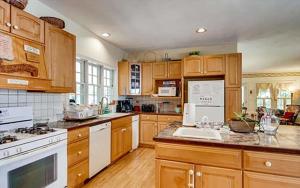 a large kitchen with wooden cabinets and white appliances at West Tisbury Inn in West Tisbury