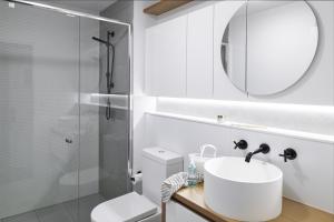 a bathroom with a shower, sink, and toilet at Punthill Ivanhoe in Melbourne
