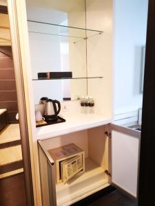 
a kitchen with a sink, microwave and refrigerator at Regalodge Hotel Ipoh in Ipoh
