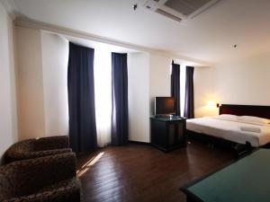 a hotel room with a bed and a chair at Regalodge Hotel Ipoh in Ipoh