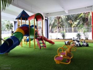 a playground with a slide on a green carpet at Traveler's homestay 旅人窝@ The Venus Sitiawan in Kampong Lumut Kiri