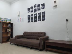 uma sala de estar com um sofá e uma estante de livros em UTHM Parit Raja Homestay em Parit Raja