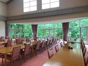 Habitación grande con mesas, sillas y ventanas. en Renaissance Tanagura, en Shirakawa