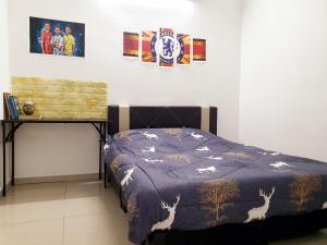 um quarto com uma cama com um edredão azul em UTHM Parit Raja Homestay em Parit Raja