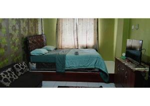 ein kleines Schlafzimmer mit einem Bett und einem Fenster in der Unterkunft Royal Property in Jakarta