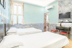 2 camas en una habitación con paredes azules en Hou Kong Hotel, en Macau