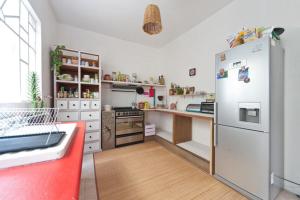 uma cozinha com um frigorífico branco e piso em madeira em Casa Índigo CDMX em Cidade do México