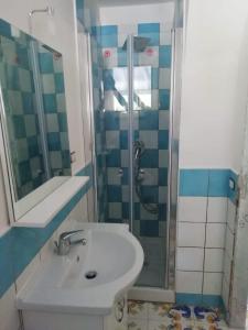 y baño con lavabo y ducha. en Casa Vacanze Baia Garagliano, en Scario