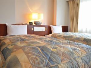横浜市にある横浜マンダリンホテルのベッドと窓が備わるホテルルーム