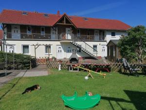 a dog laying in the grass in front of a house at Urlaub beim Schmied in Kühlungsborn