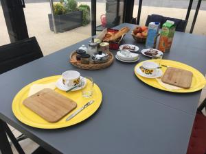 a blue table with yellow plates and cups and bread at Maison d’izier in Izier +36 photos