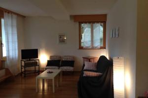 ein Wohnzimmer mit einem Sofa und einem Tisch in der Unterkunft Apartment Del Sol Etoile 1 Crans Montana Switzerland in Crans-Montana