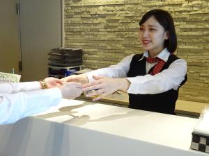 a woman is shaking hands with a man at Hotel Green With in Sendai