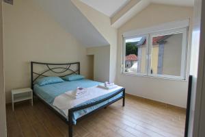 a bedroom with a bed and a large window at Apartmani Poeta in Trebinje