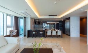 釜山的住宿－LCT Residence，一间带白色沙发的客厅和一间厨房