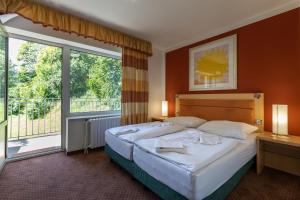 una camera da letto con un letto e una grande finestra di Active & Wellness Hotel Subterra a Ostrov