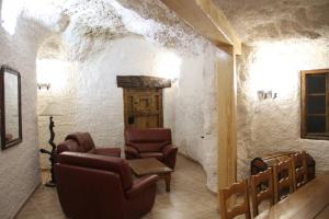 una sala de estar con sillas y una puerta en una pared de piedra. en CUEVAS AL ANDALUS - Granaina, en Orce