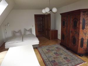 a bedroom with a bed and a wooden cabinet at Große Ferienwohnung am grünen Stadtrand in Erfurt