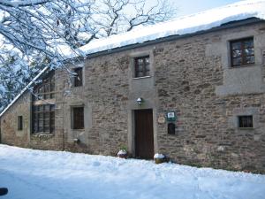 un edificio de piedra con una puerta en la nieve en Rodeo Da Casa, en O Reto 