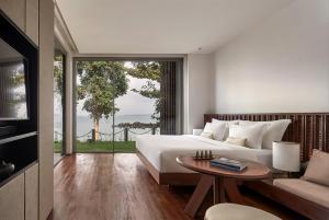 Phumĭ Kaôh Rœssei的住宿－Koh Russey Resort，一间卧室配有一张床、一张桌子和一张沙发