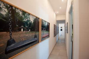 a hallway with a row of paintings on the wall at B&B ICHOME NAPOLI - Maison d'Artiste in Naples
