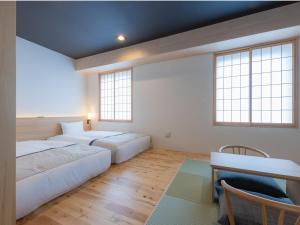 two beds in a room with two windows at Tosei Hotel Cocone Asakusa Kuramae in Tokyo