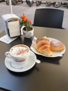 - une tasse de café et des croissants sur une table avec une tasse de café dans l'établissement Hall inn B&B in Chiostro, à Naples