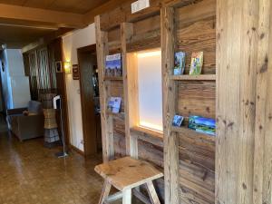 a room with a wooden wall with a table and a stool at Hotel Garnì Savoy in Castelrotto