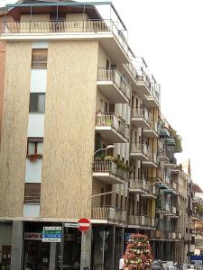 un grand bâtiment avec balcon et un arbre de Noël en face de celui-ci dans l'établissement Appartamento La Ninfea, à Arona